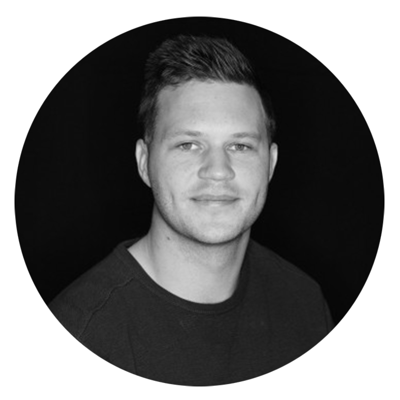 Smiling man with short hair, black background.