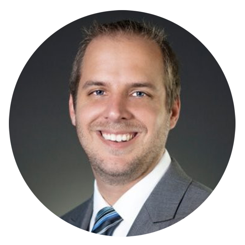 Man in a suit smiling at the camera.